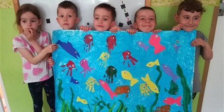 Powiększ grafikę: Dzieci trzymają w rękach wykonaną makietę przedstawiającą podwodny świat. Praca została wykonana przez dzieci samodzielnie. 